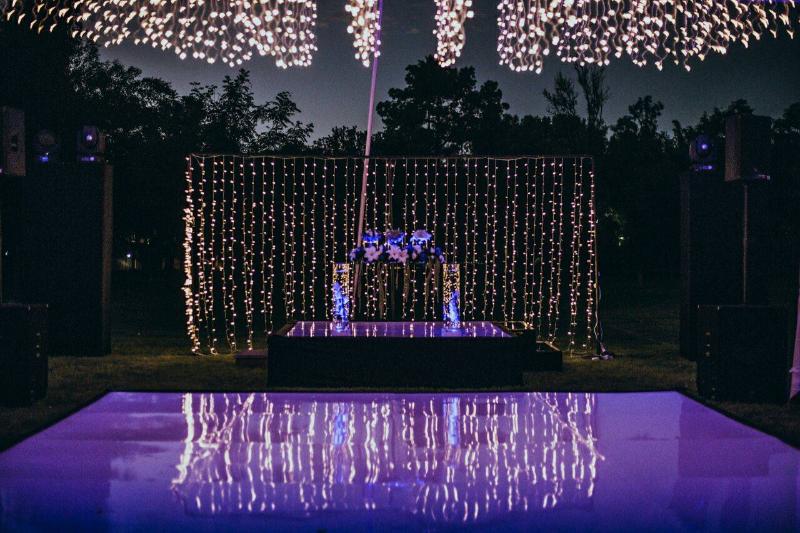 Cortina de luz detrás de la pista y luces sobre los árboles